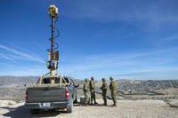 Army soldiers look at the border wall next to a surveillance vehicle during the visit to the U.S. and Mexico border by Defense Secretary Pete Hegseth