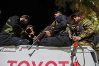 Syria's security forces stand on their vehicle