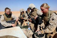 Marines with the Lioness Program refill their rifle magazines during the live-fire portion of their training at Camp Korean Village, Iraq
