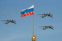 Russian Tu-95 strategic bombers fly past a Russian flag at the Kremlin