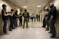 Federal agents wait outside an immigration courtroom