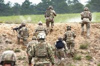 U.S. Army fire teams head over the bunker during a squad live fire assault mission