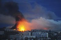 Fire and smoke rise from the site where a Russian missile struck a residential area in Kharkiv, Ukraine
