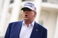 President Donald Trump talks with reporters before a flag pole is installed
