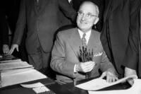 President Harry Truman holds up a handful of pens