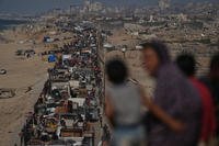 Displaced Palestinians flee northern Gaza Strip, by foot and in vehicles, carrying their belongings along the coastal road, near Wadi Gaza