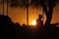 A guardsman stands at a gate to Shelby Park in Eagle Pass, Texas.