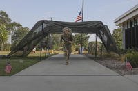 Spc. Tom Hook, a religious affairs specialist attached to the 185th Combat Sustainment Support Battalion, Iowa Army National Guard, crosses the finish line of a 12-mile ruck march event during the 2026 Iowa National Guard Best Warrior Competition at Johnston Town Center, Johnston, Iowa.