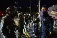 Federal agents stand guard to keep demonstrators away from an Immigration and Customs Enforcement (ICE) facility in downtown Portland, Oregon.