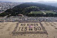 This aerial picture taken on Saturday, Oct. 18, 2025, shows protesters forming a human banner during the ‘No Kings’ national day of protest on Ocean Beach in San Francisco.