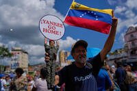 A man holds a doll of late President Hugo Chavez near the United Nations' office in Caracas, Venezuela, during a government-organized rally against foreign interference on Monday, Oct. 6, 2025. (AP Photo/Ariana Cubillos)