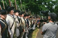Camera operator films a line of Revolutionary War reenactors for Ken Burns’ PBS docuseries The American Revolution.