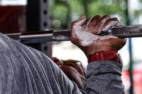 Closeup of a weightlifter's hand while performing a bench press.