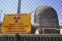 A sign warning of radioactive materials is seen on a fence around a nuclear reactor containment building, April 26, 2021, a few days before it stopped generating electricity at Indian Point Energy Center in Buchanan, N.Y. (AP Photo/Seth Wenig, File)