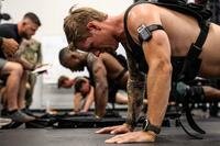 Sailors in weight vests do pushups.