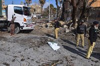 Police officers examine the site of a suicide bombing in Pakistan.