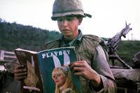 U.S. soldier Dan Mouer reads a copy of Playboy magazine in Vietnam in 1966 while seated near military equipment. (Courtesy of Dan Mouer)