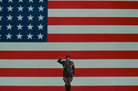 George C. Scott salutes in front of a large American flag in Patton. Photo credit: 20th Century Fox