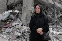 A woman stands near rubble across from a building damaged last Sunday during the U.S.-Israeli air campaign in Tehran, Iran, Thursday, March 12, 2026. (AP Photo/Vahid Salemi)