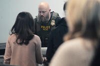 An Immigration and Customs Enforcement (ICE) agent works at the baggage check at O'Hare International Airport in Chicago, Tuesday, March 24, 2026. (AP Photo/Nam Y. Huh)