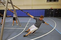 A recreation assistant performs a Total Body Resistance Exercise (TRX) upper-body exercise.