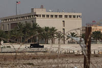 A Bahraini armored personnel vehicle and personnel reinforce U.S. Embassy security just outside of a gate to the building, surrounded in barbed wire, in Manama, Bahrain, on Sunday, Aug. 4, 2013.