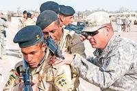Sgt. David Kappel (right), an infantry trainer assigned to 1st Armored Brigade Combat Team, 1st Infantry Division, adjusts the rifle of an Iraqi army trainee Jan. 7 at Camp Taji, Iraq. (U.S. Army photo)