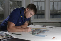 Coast Guard Petty Officer 1st Class Justin Lacy, a boatswain's mate, works on chart art for Coast Guard Station Atlantic City, N.J., June 9, 2015. (U.S. Coast Guard photo/Chief Petty Officer Nick Ameen)