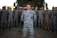 Senior Airman Zach White, a 332nd Expeditionary Civil Engineer Squadron firetruck operator and truck engineer, stands in front of his firefighter comrades in Southwest Asia, Aug. 20, 2015. (U.S. Air Force photo/Senior Airman Racheal E. Watson)