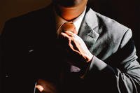 man in suit adjusting his tie