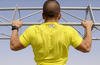 Senior airman does pull-ups during workout in Southeast Asia.