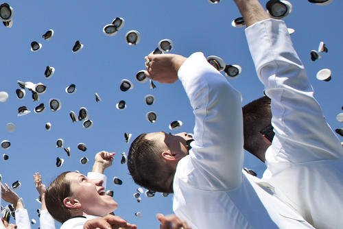Naval Academy graduates toss their covers into the air during the 2015 Naval Academy graduation and commissioning ceremony.