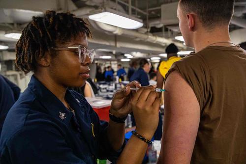 Hospital Corpsman administers a vaccination to a sailor.