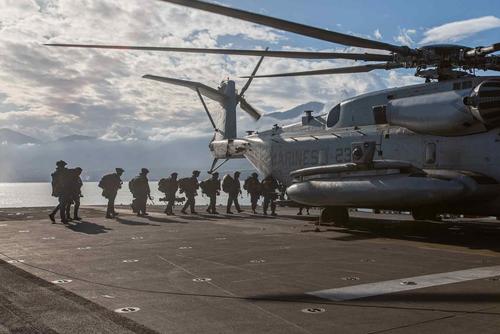 U.S. Marines board a CH-53E Super Stallion aboard the USS Bataan
