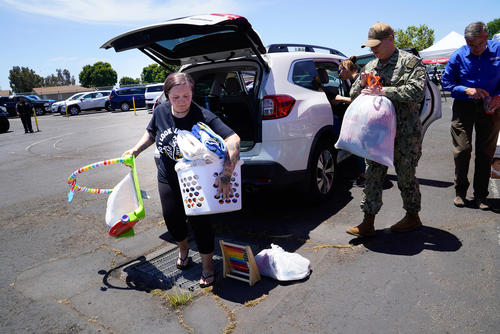 Courtney Bouma, a Navy dependent, arrives with items to be used for those who were evacuated after a small plane crashed early Thursday morning, May 22, 2025, in a heavily military community near San Diego, killing 6 and injuring 8.