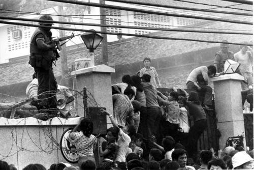 mobs of Vietnamese people scale the wall of the U.S. Embassy in Saigon, Vietnam