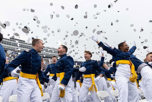 The U.S. Air Force Academy Class of 2025 graduates toss their hats skyward at Falcon Stadium in Colorado Springs
