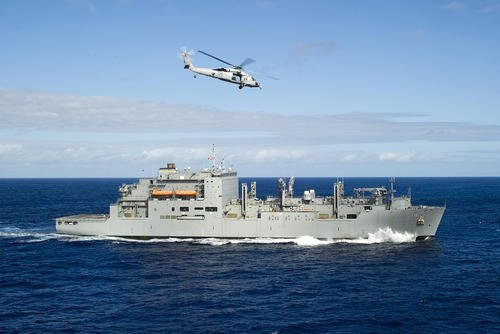 A U.S. Navy Sikorsky MH-60S Sea Hawk helicopter assigned to Helicopter Sea Combat Squadron (HSC) 21 maneuvers toward the U.S. Military Sealift Command dry cargo and ammunition ship USNS Cesar Chavez (T-AKE-14) during a vertical replenishment with the amphibious assault ship USS Peleliu (LHA-5), not pictured, in the Pacific Ocean.