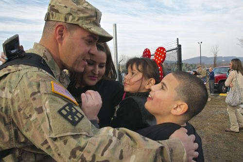 Spc. Elias Baez-Cintron, a light wheel mechanic with 333rd Engineer Company, greets his wife and kids during a welcome home ceremony after an 11-month deployment to Afghanistan. Photo by Sgt. 1st Class Julio Nieves